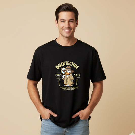 Man wearing a black t-shirt with a duck detective graphic on a beige background